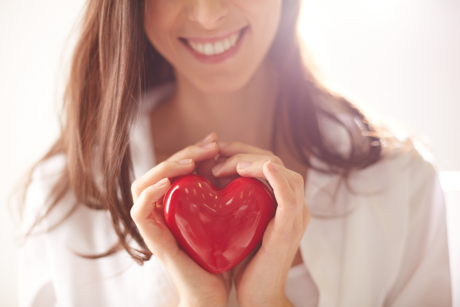 Woman holding a red heart in her hands